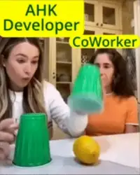 AHK Developer and CoWorker label over two women in a kitchen playing a cup-stacking game with green cups and a lemon